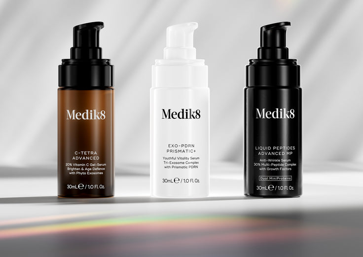 Three Medik8 skincare serums on a gradient background