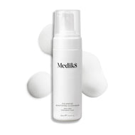 Medik8 Calmwise Soothing Cleanser pump bottle displayed on a white background with a smear of white foam behind it, highlighting the product's texture.