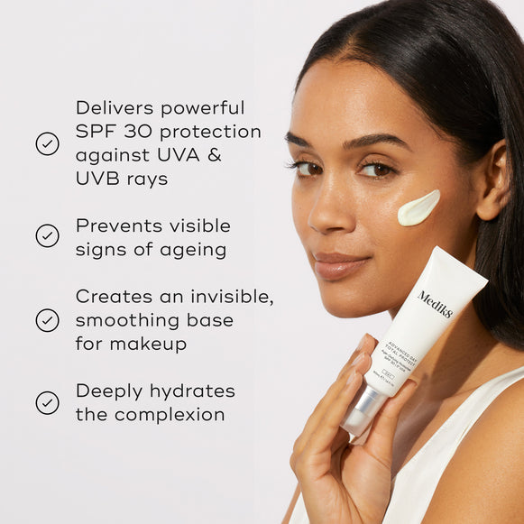 A model holding the Medik8 Advanced Day Total Protect tube next to a list of benefits with checkmark icons. Text highlights that it delivers powerful SPF 30 protection against UVA and UVB rays, prevents visible signs of ageing, creates an invisible smoothing base for makeup, and deeply hydrates the complexion.-hover-10