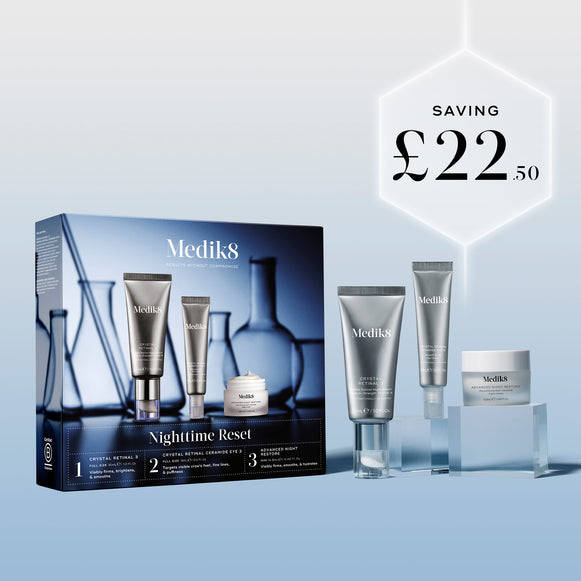 The Medik8 Nighttime Reset kit box and products displayed on clear blocks against a blue background. A glowing hexagonal graphic highlights a saving of "£22.50."-2
