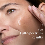Close-up of a woman applying Medik8 serum to her cheek with text referencing full-spectrum results.