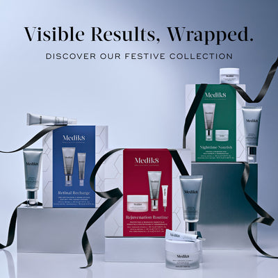 A display of three Medik8 festive gift boxes adorned with black ribbons against a light grey background, titled "Visible Results, Wrapped. Discover Our Festive Collection." It features the blue Retinal Recharge box with two tubes, the red Rejuvenation Routine box with a cream jar, tube, and pump bottle, and the green Nighttime Nourish box with a tube and cream jar.
