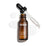 A bottle of Medik8 C-Tetra Lipid Vitamin C Radiance Serum open with its dropper resting diagonally across the top. Set against a clean white background, the bottle is surrounded by three clear puddles of serum, showcasing its liquid texture.