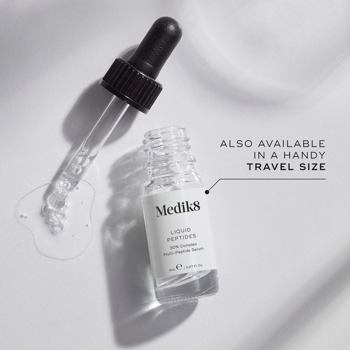 A small clear glass bottle (8mL) of Medik8 Liquid Peptides serum, with its dropper resting beside it. Text indicates it's "ALSO AVAILABLE IN A HANDY TRAVEL SIZE.