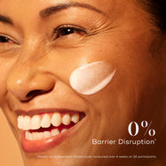 Smiling woman with radiant skin and a swipe of Medik8 C-Tetra Advanced serum on her cheek, emphasising 0% barrier disruption for gentle yet effective brightening.